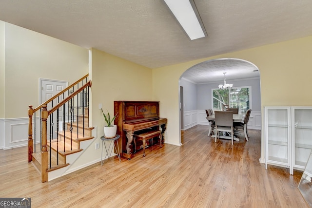 3668 Burel Mill Dr, Buford, GA 30519 - living area featuring arched walkways, a decorative wall, a chandelier, light wood-style flooring, and stairway