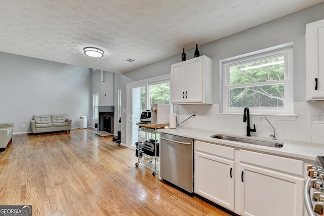 3668 Burel Mill Dr, Buford, GA 30519 - kitchen featuring appliances with stainless steel finishes, a sink, white cabinets, backsplash, and healthy amount of natural light