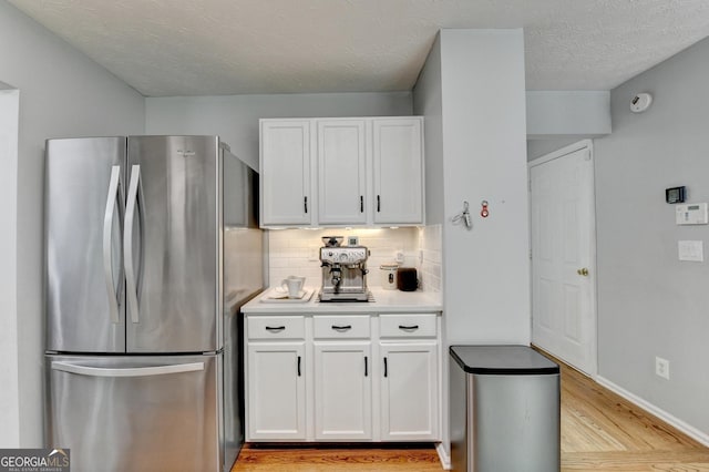 3668 Burel Mill Dr, Buford, GA 30519 - kitchen with freestanding refrigerator, white cabinetry, light wood-style flooring, and tasteful backsplash