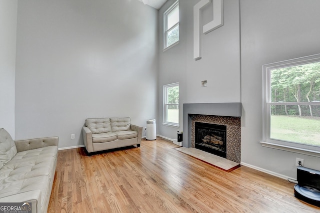 3668 Burel Mill Dr, Buford, GA 30519 - living room featuring a high ceiling, wood finished floors, a fireplace with flush hearth, and baseboards