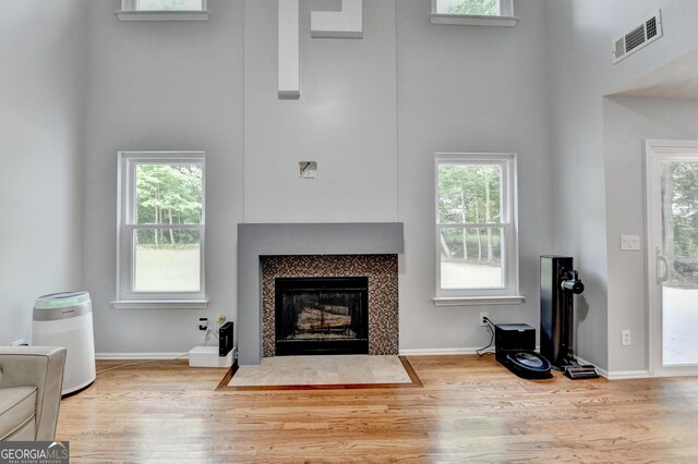 3668 Burel Mill Dr, Buford, GA 30519 - living area with a high ceiling, wood finished floors, a fireplace with flush hearth, plenty of natural light, and baseboards