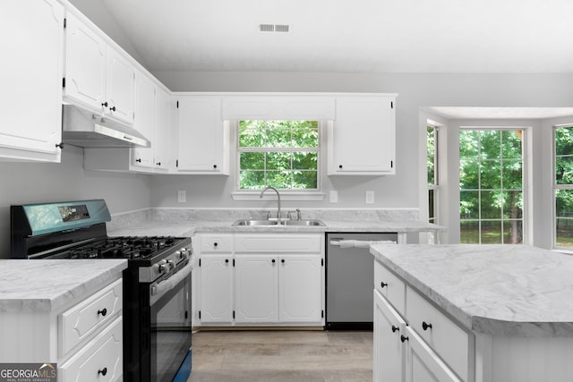 kitchen featuring under cabinet range hood, appliances with stainless steel finishes, a sink, and white cabinetry