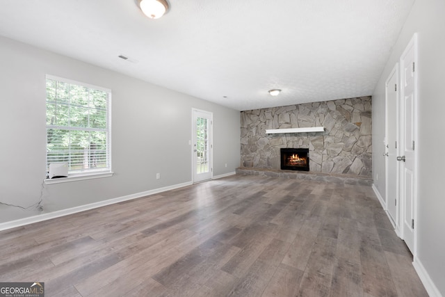 unfurnished living room featuring wood finished floors, a fireplace, and baseboards
