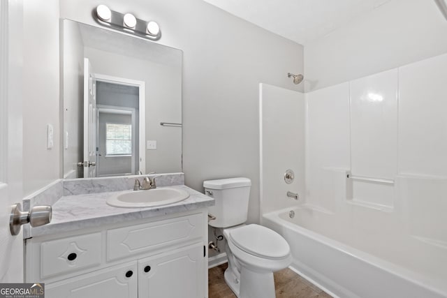full bath with toilet, wood finished floors, vanity, and bathing tub / shower combination