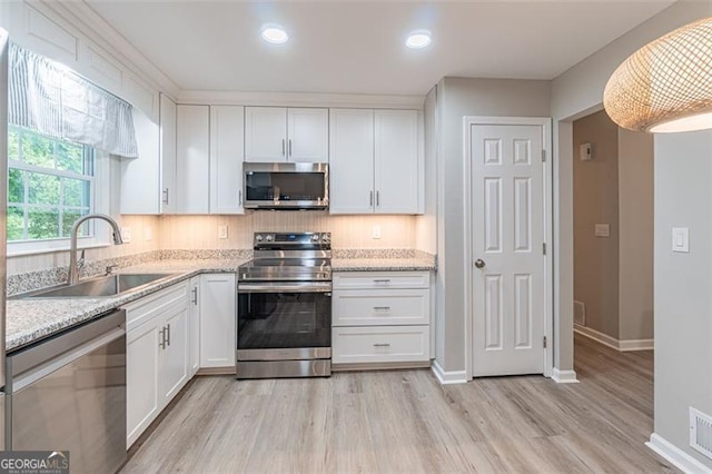 4171 Whispering Forest Ct SW, Lilburn, GA 30047 - kitchen with appliances with stainless steel finishes, a sink, white cabinets, light wood-style floors, and baseboards