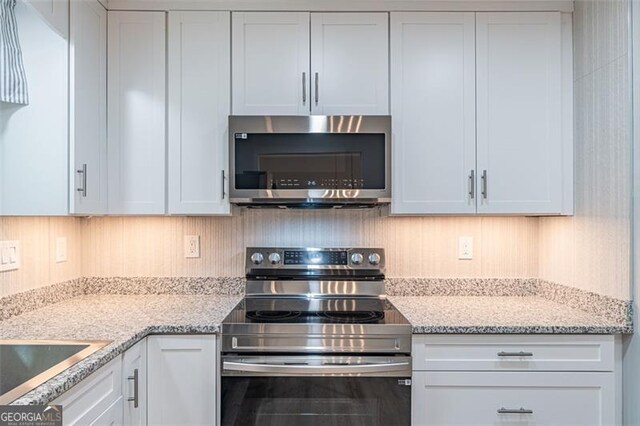 4171 Whispering Forest Ct SW, Lilburn, GA 30047 - kitchen with stainless steel appliances, white cabinets, and light stone countertops