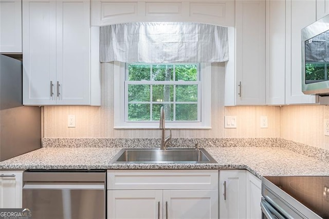 4171 Whispering Forest Ct SW, Lilburn, GA 30047 - kitchen featuring appliances with stainless steel finishes, a sink, white cabinets, and light stone counters