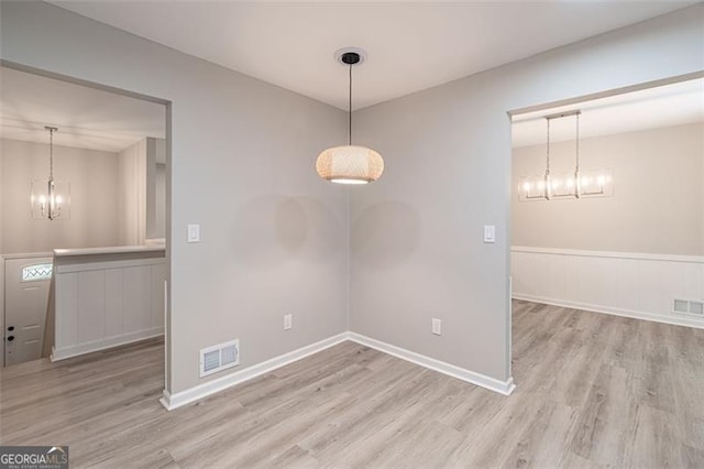 4171 Whispering Forest Ct SW, Lilburn, GA 30047 - unfurnished room with a chandelier, wood finished floors, a wainscoted wall, and baseboards