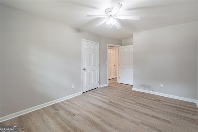 4171 Whispering Forest Ct SW, Lilburn, GA 30047 - unfurnished bedroom with baseboards, wood finished floors, and a ceiling fan