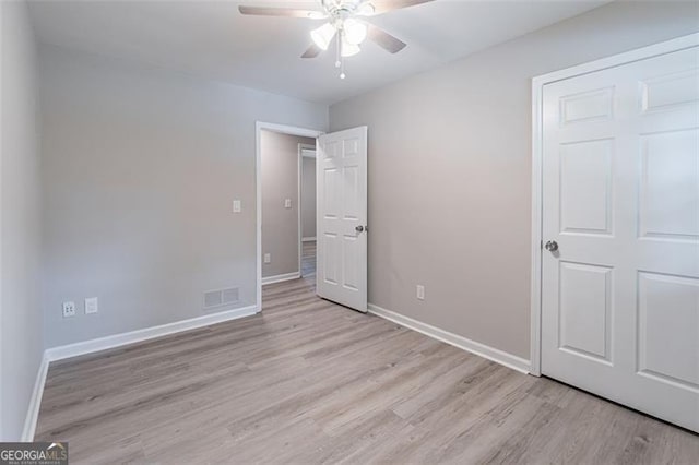 4171 Whispering Forest Ct SW, Lilburn, GA 30047 - unfurnished bedroom featuring light wood-style flooring, baseboards, and a ceiling fan