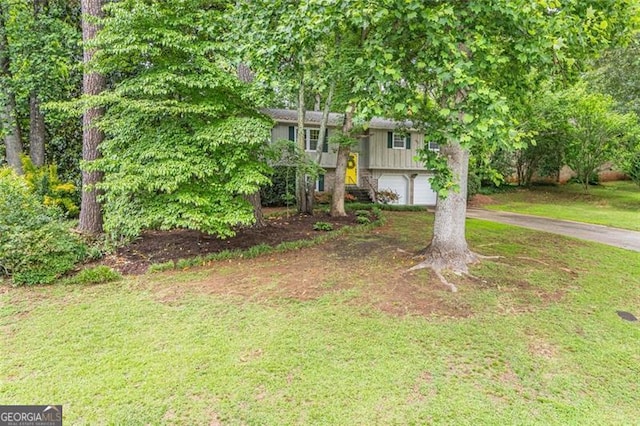 4171 Whispering Forest Ct SW, Lilburn, GA 30047 - raised ranch featuring asphalt driveway, an attached garage, and a front yard