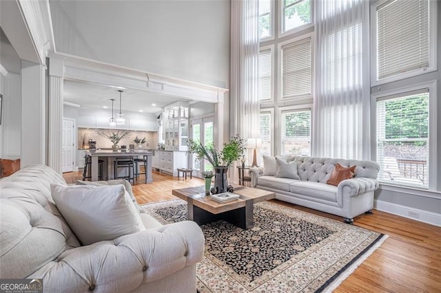 5370 Newport Bay, Alpharetta, GA 30005 - living area with a high ceiling, plenty of natural light, light wood-style floors, and baseboards