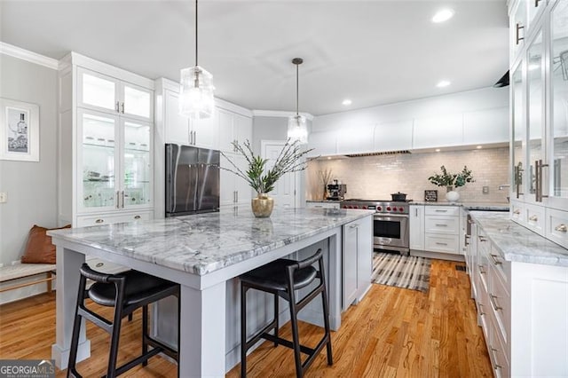 5370 Newport Bay, Alpharetta, GA 30005 - kitchen with appliances with stainless steel finishes, a kitchen bar, a center island, backsplash, and white cabinets