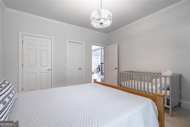 carpeted bedroom with ornamental molding, a chandelier, and baseboards