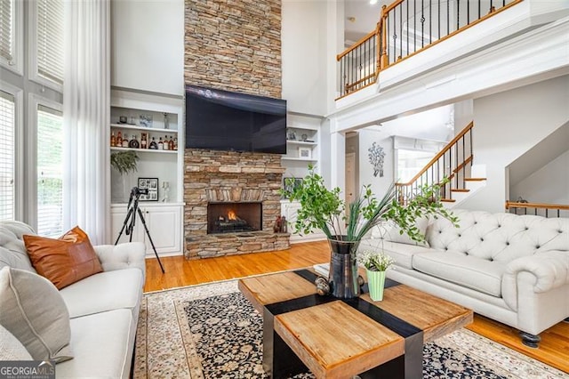 5370 Newport Bay, Alpharetta, GA 30005 - living area with a high ceiling, wood finished floors, stairway, a stone fireplace, and built in shelves