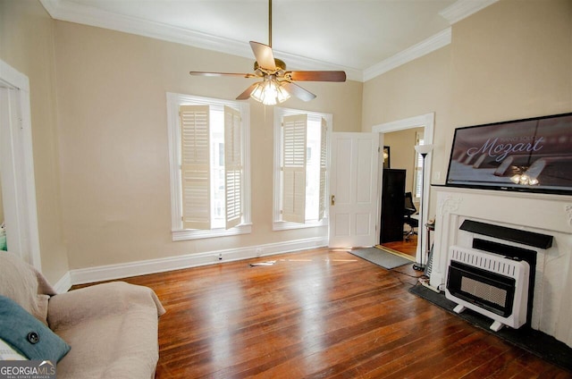 living room with heating unit, ornamental molding, wood finished floors, a ceiling fan, and baseboards