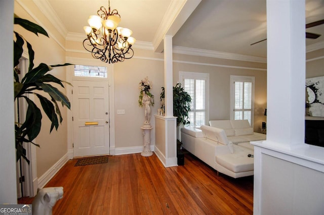 foyer featuring crown molding, wood finished floors, a chandelier, and baseboards