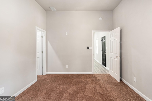 unfurnished room with carpet and baseboards