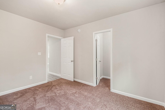 unfurnished bedroom featuring carpet floors and baseboards
