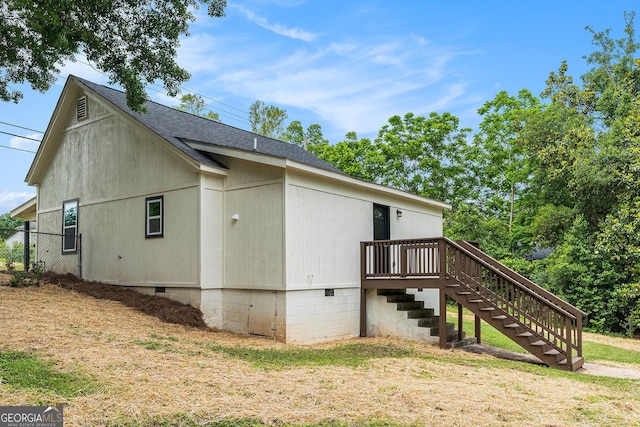 view of side of home with stairs, roof with shingles, crawl space, fence, and a wooden deck