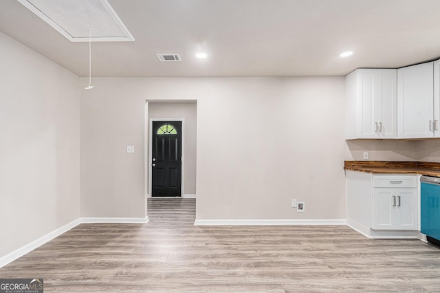 unfurnished dining area featuring attic access, light wood-style flooring, baseboards, and recessed lighting