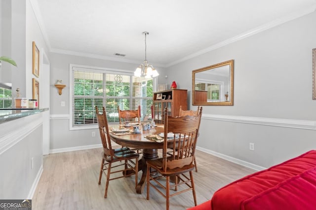 1152 Strath Clyde Way, Mcdonough, GA 30253 - dining space featuring light wood-type flooring, plenty of natural light, a chandelier, and crown molding