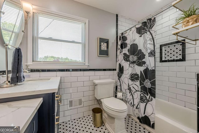 27 Graham Rd, Dallas, GA 30132 - bathroom with vanity, toilet, shower / bath combination with curtain, tile patterned floors, and tile walls