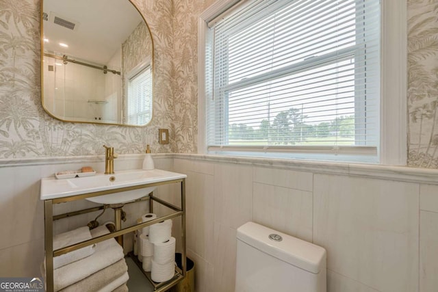 27 Graham Rd, Dallas, GA 30132 - bathroom featuring wallpapered walls, a wainscoted wall, toilet, a shower, and a sink