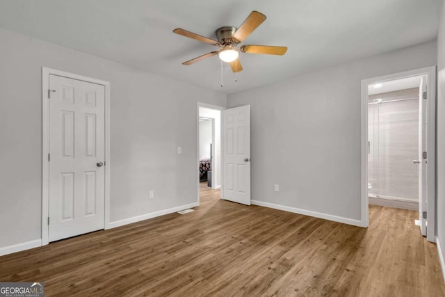 2184 Cherokee Valley Cir, Lithonia, GA 30058 - unfurnished bedroom with wood finished floors, ensuite bathroom, and a ceiling fan