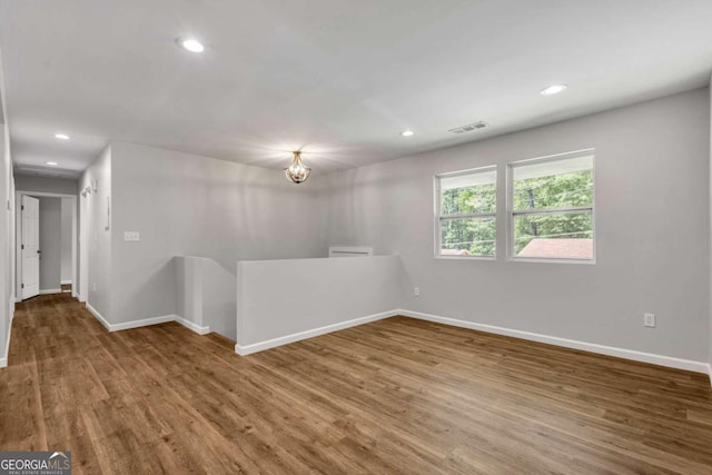 spare room featuring wood finished floors, baseboards, and recessed lighting