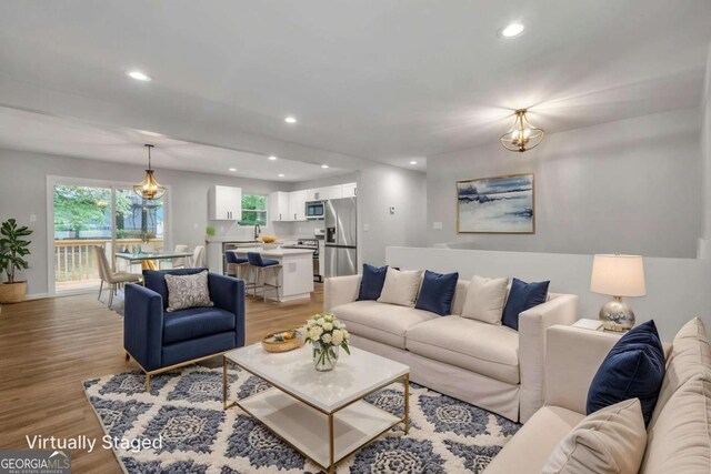 living area with light wood-type flooring, recessed lighting, and baseboards