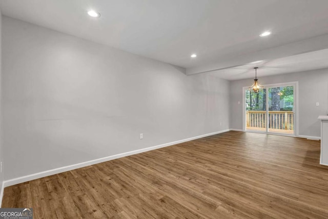 spare room featuring baseboards, wood finished floors, and recessed lighting