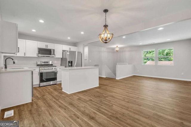 2184 Cherokee Valley Cir, Lithonia, GA 30058 - kitchen with appliances with stainless steel finishes, a chandelier, recessed lighting, light countertops, and white cabinets