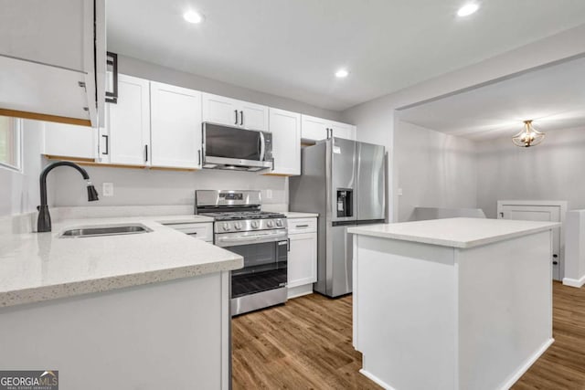 2184 Cherokee Valley Cir, Lithonia, GA 30058 - kitchen with stainless steel appliances, wood finished floors, white cabinets, a center island, and recessed lighting