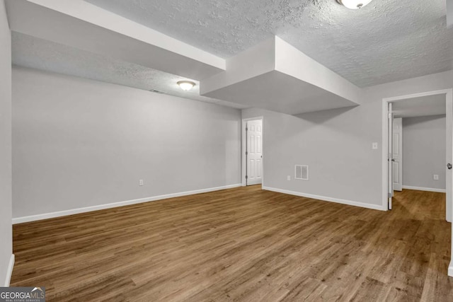 2184 Cherokee Valley Cir, Lithonia, GA 30058 - finished basement with a textured ceiling and wood finished floors