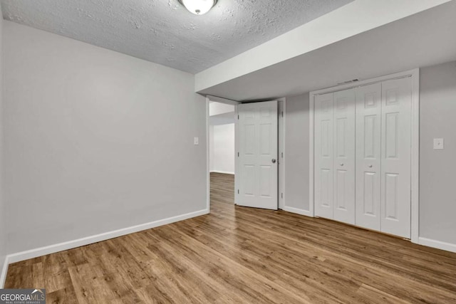 2184 Cherokee Valley Cir, Lithonia, GA 30058 - unfurnished bedroom with wood finished floors, a textured ceiling, and a closet