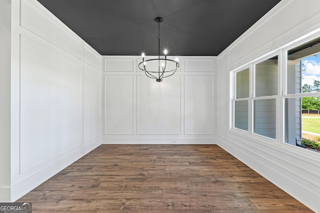 1356 Waymanville Rd, Thomaston, GA 30286 - unfurnished dining area with a decorative wall, a chandelier, and dark wood-style floors