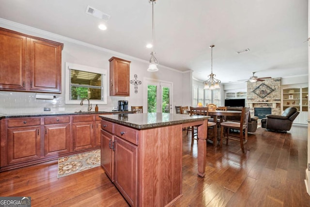 3230 Sundew Dr NW, Acworth, GA 30101 - kitchen with a fireplace, a sink, a ceiling fan, a kitchen island, and dark wood-type flooring