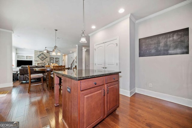 3230 Sundew Dr NW, Acworth, GA 30101 - kitchen with dark wood-style flooring, baseboards, dark stone countertops, crown molding, and a center island