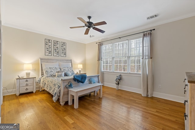 bedroom featuring ornamental molding, baseboards, light wood-style flooring, and ceiling fan