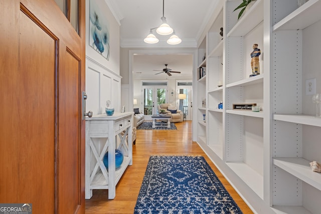 entrance foyer with crown molding, ceiling fan, and light wood finished floors