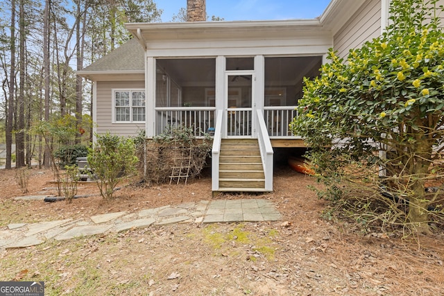 property entrance featuring a chimney and a shingled roof
