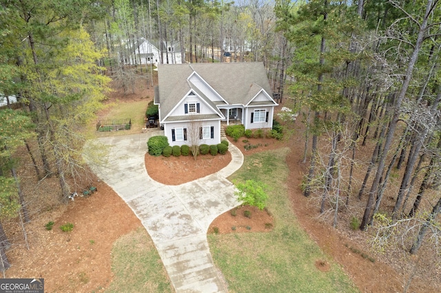 view of front of house featuring concrete driveway and a shingled roof