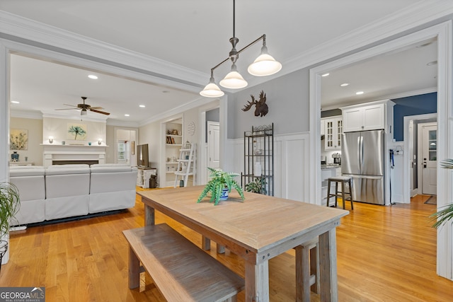 dining room with light wood-type flooring, ceiling fan, ornamental molding, and recessed lighting