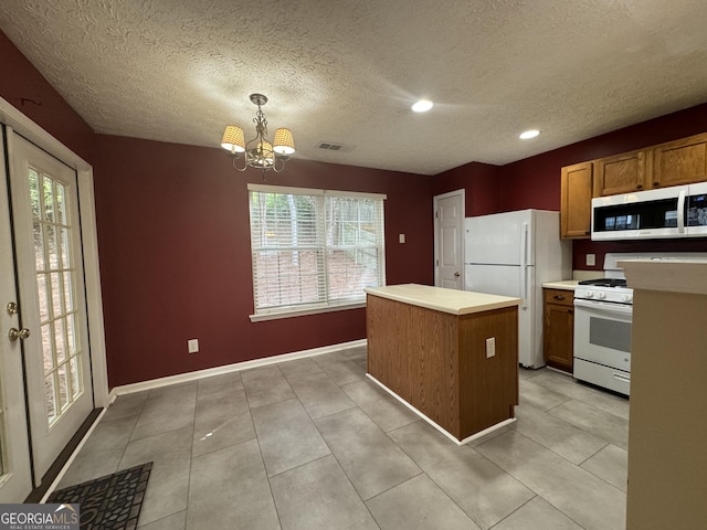218 Osmanthus Way, Canton, GA 30114 - kitchen featuring white appliances, a chandelier, a center island, brown cabinetry, and a textured ceiling