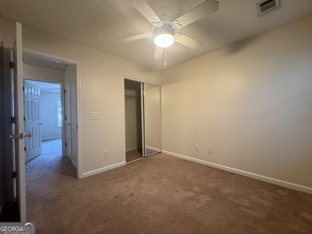 218 Osmanthus Way, Canton, GA 30114 - unfurnished bedroom with carpet floors, a closet, a textured ceiling, and a ceiling fan
