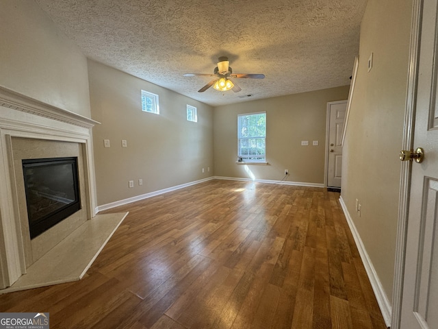 218 Osmanthus Way, Canton, GA 30114 - unfurnished living room featuring a ceiling fan, wood-type flooring, a fireplace, and a textured ceiling