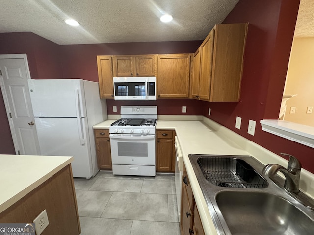 218 Osmanthus Way, Canton, GA 30114 - kitchen featuring white appliances, a sink, a textured ceiling, brown cabinetry, and light countertops