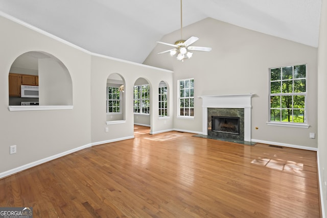 74 Rotunda Ct, Dallas, GA 30157 - unfurnished living room with ceiling fan, healthy amount of natural light, light wood finished floors, a premium fireplace, and high vaulted ceiling