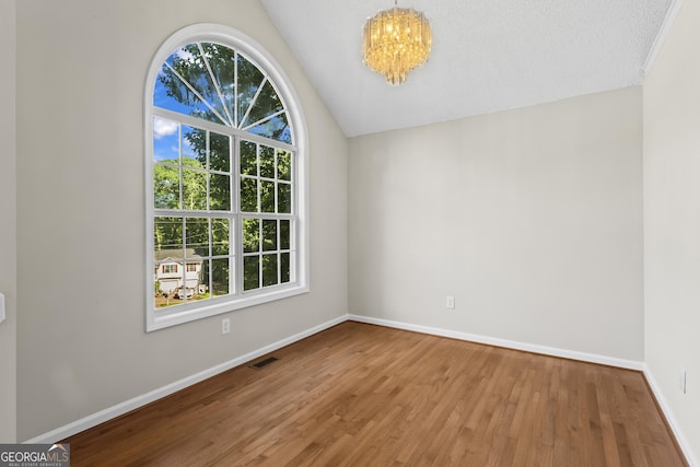 74 Rotunda Ct, Dallas, GA 30157 - unfurnished room with plenty of natural light, wood finished floors, a chandelier, baseboards, and lofted ceiling